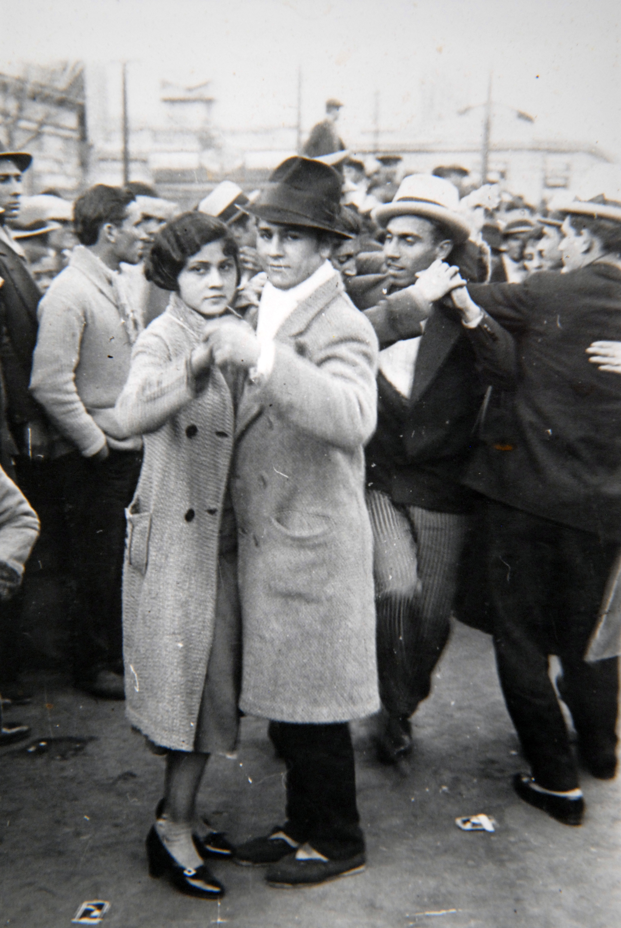 Parejas bailan tango en la calle.