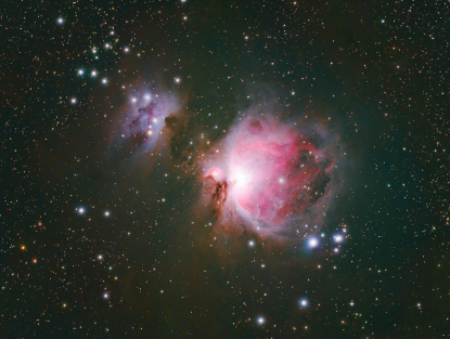 Cielo nocturno con estrellas y una nebulosa.