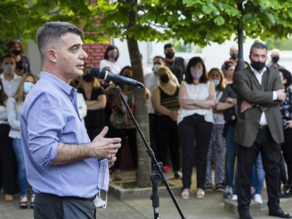Rubén D'Audia habla con las y los trabajadores de Educ.ar S. E. con un micrófono de pie. De fondo, varias personas lo escuchan con barbijos puestos.