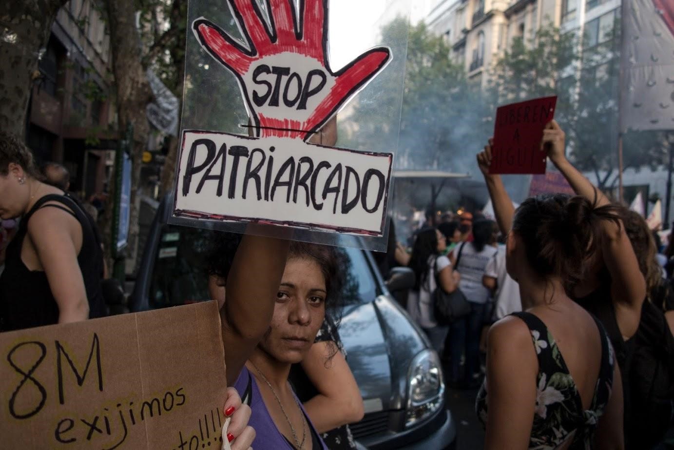 Fotografía color tomada durante una marcha del 8M, Día Internacional de la Mujer. En la calle, una mujer sostiene un cartel con el texto: Stop patriarcado.