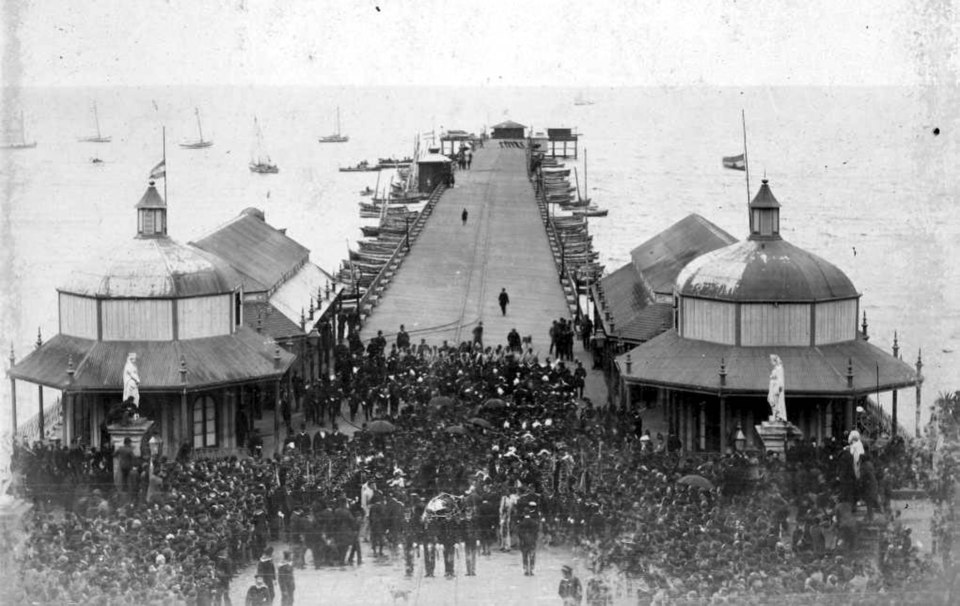 Fotografía en blanco y negro de una multitud en un muelle recibiendo los restos de Sarmiento.