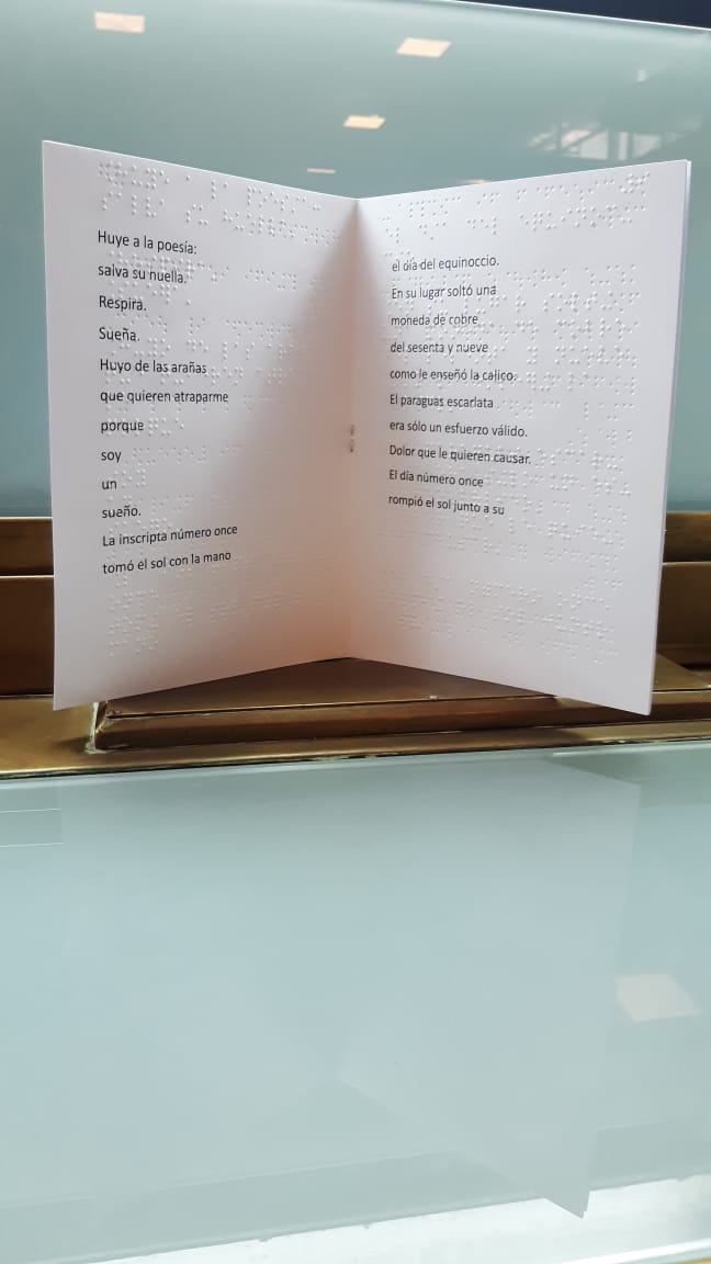 Fanzine en exhibición con un poema impreso en tinta y en braille.