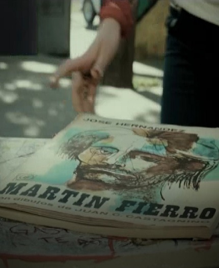 La mano de una persona se acerca a la portada de Martín Fierro.