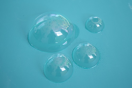 Tres burbujas sobre una mesa celeste.