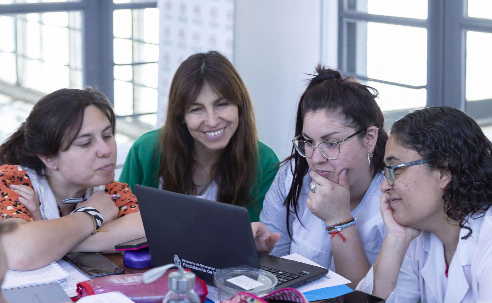 Docentes trabajando juntas con una netbook.