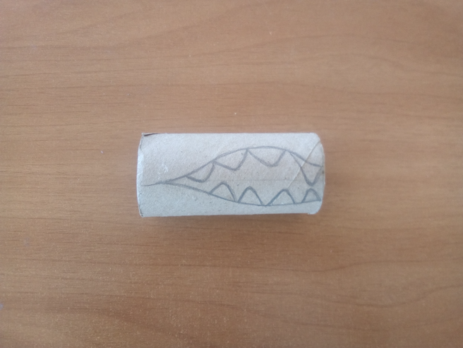 Tubo con el dibujo de una boca abierta de dragón con dientes en forma de triángulo.