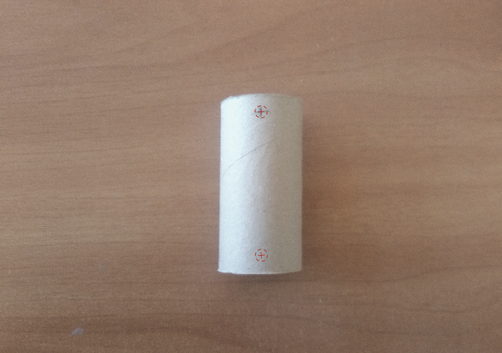 Tubo de cartón chico con dos marcas para realizar los agujeros.