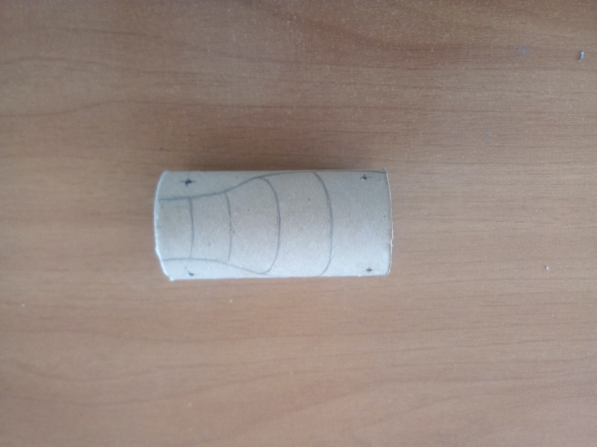 Tubo de cartón chico con el dibujo de la panza de un dragón.