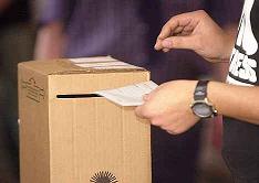 Una persona ingresa un voto en una urna electoral.
