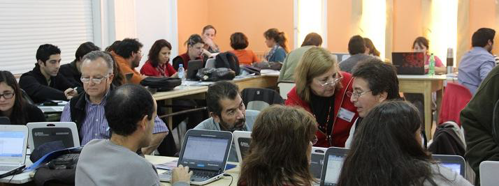Grupo de docentes sentados en un salón utilizando netbooks.