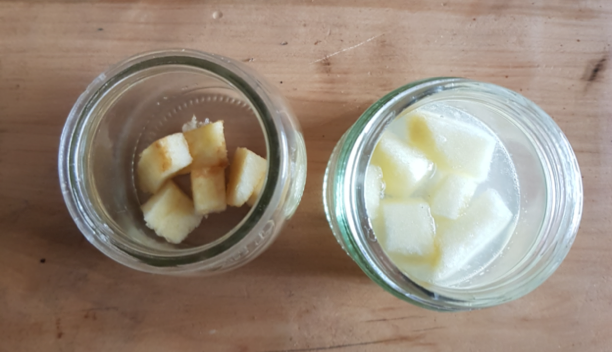 El primer recipiente con cubitos de manzana amarronados, el segundo con cubitos de manzana blancos sumergidos en jugo de limón.