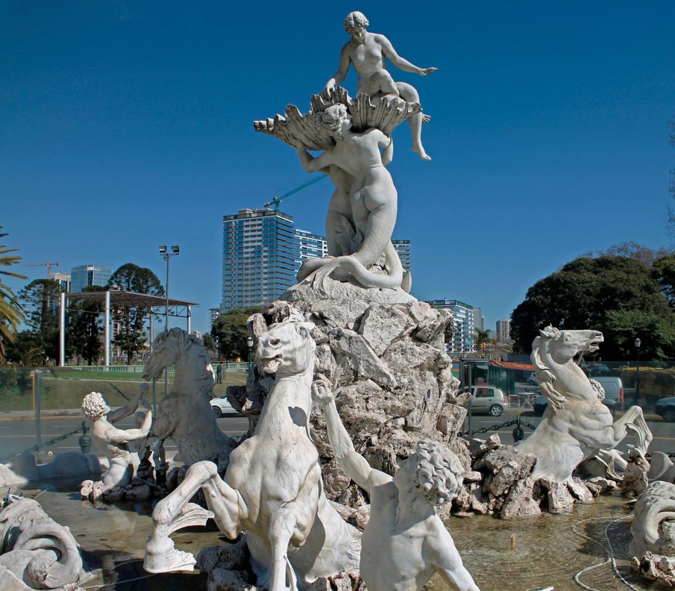 Fuente de las Nereidas, de Lola Mora, bajo un cielo despejado. Al fondo, hay edificios.