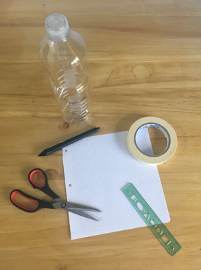 Una tijera, cinta adhesiva, una botella de plástico, una lapicera, una regla y una hoja de papel.