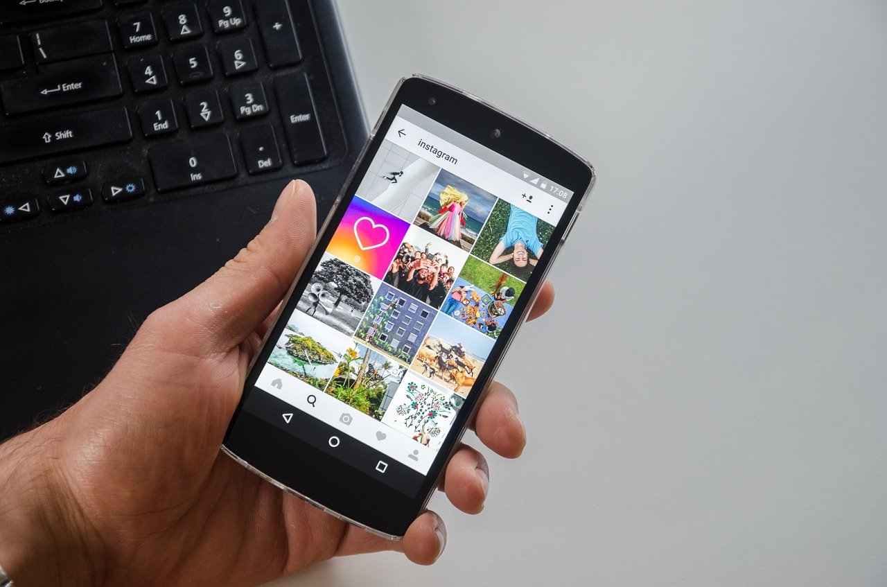 Una mano sostiene un celular con Instagram en la pantalla.