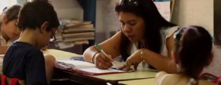 Una maestra con sus alumnos en un aula.